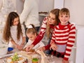 Family with children rolling dough in Xmas kitchen. Royalty Free Stock Photo