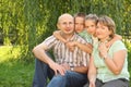 Family with children sitting at grass near osier Royalty Free Stock Photo