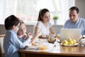 Family with children using gadgets sitting at the dining table Royalty Free Stock Photo