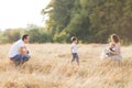 Family with children walking outdoors in summer field at sunset. Father, mother and two children sons having fun in Royalty Free Stock Photo