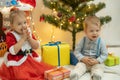 Family on Christmas eve at fireplace. Mother and little kids opening Xmas presents. Children with gift boxes. Living Royalty Free Stock Photo