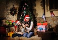 Family on Christmas eve. Mother and daughter and dog with Xmas presents. Family with gift boxes. Living room with decorated tree. Royalty Free Stock Photo