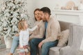 Family Christmas morning in a bright minimalistic living room near the Christmas tree. Royalty Free Stock Photo