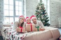 Family in Christmas Santa hats lying on bed Royalty Free Stock Photo