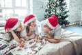 Family in Christmas Santa hats lying on bed Royalty Free Stock Photo