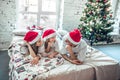 Family in Christmas Santa hats lying on bed Royalty Free Stock Photo