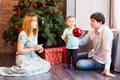 Family, christmas, x-mas, winter, happiness and people concept - smiling family with baby boy sitting under xmas tree Royalty Free Stock Photo