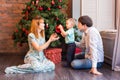 Family, christmas, x-mas, winter, happiness and people concept - smiling family with baby boy sitting under xmas tree Royalty Free Stock Photo