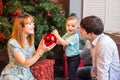 Family, christmas, x-mas, winter, happiness and people concept - smiling family with baby boy sitting under xmas tree Royalty Free Stock Photo