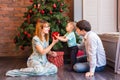 Family, christmas, x-mas, winter, happiness and people concept - smiling family with baby boy sitting under xmas tree Royalty Free Stock Photo