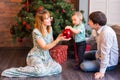 Family, christmas, x-mas, winter, happiness and people concept - smiling family with baby boy sitting under xmas tree Royalty Free Stock Photo