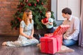 Family, christmas, x-mas, winter, happiness and people concept - smiling family with baby boy sitting under xmas tree Royalty Free Stock Photo