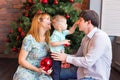 Family, christmas, x-mas, winter, happiness and people concept - smiling family with baby boy sitting under xmas tree Royalty Free Stock Photo