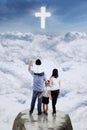 Family on the cliff and looking at the cross sign Royalty Free Stock Photo