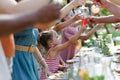 Family clinking glasses at summer garden party, kids clinking with nonalcoholic drink, lemonade. Celebratory toast at