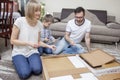 Family composed of mom, dad and boy turns furniture on the carpet having fun. Royalty Free Stock Photo