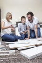 Family composed of mom, dad and boy turns furniture on the carpet having fun. Royalty Free Stock Photo