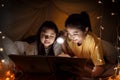 Family concept. elder sister and sister reading book with flashlight together before bedtime. Sister read story book together in Royalty Free Stock Photo