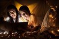Family concept. elder sister and sister reading book with flashlight together before bedtime. Sister read story book together in Royalty Free Stock Photo