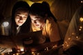 Family concept. Mother and child daughter reading book with flashlight together in children tent before bedtime. Happy mother read Royalty Free Stock Photo