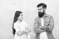 Family conflict. Bearded hipster man and child girl. Confrontation concept. Frowning man and serious daughter. Solving