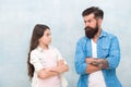Family conflict. Bearded hipster man and child girl. Confrontation concept. Frowning man and serious daughter. Solving
