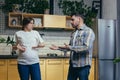 Family conflict. Young family. A pregnant woman and a man quarrel at home, shouting. They stand at home in the kitchen Royalty Free Stock Photo