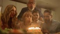 Family congratulating grandmother on birthday. Woman blowing candles on cake Royalty Free Stock Photo