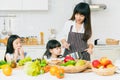 Family cooking in the kitchen with children happy enjoy eating healthy food fruits and vegetable, candid moment together Royalty Free Stock Photo