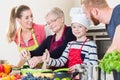 Family cooking in multigenerational household with son, mother,