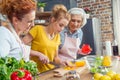 Happy three-generation family cooking together vegetable salad