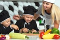 A family of cooks.Healthy eating. Happy family mother and children prepares vegetable salad in kitchen Royalty Free Stock Photo