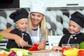 A family of cooks.Healthy eating. Happy family mother and children prepares vegetable salad in kitchen Royalty Free Stock Photo