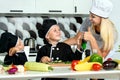 A family of cooks.Healthy eating. Happy family mother and children prepares vegetable salad in kitchen Royalty Free Stock Photo