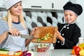 A family of cooks.Healthy eating.Mother and children prepares vegetable salad in kitchen. Royalty Free Stock Photo