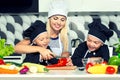 A family of cooks.Healthy eating.Mother and children prepares vegetable salad in kitchen. Royalty Free Stock Photo