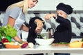 A family of cooks.Healthy eating.Mother and children prepares vegetable salad in kitchen. Royalty Free Stock Photo