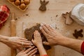 The family cooks homemade ginger cookies for Christmas. Moms, father`s hands and son`s hands on the dough against the background