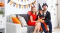 family in costumes getting ready for halloween at home Royalty Free Stock Photo