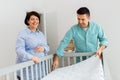 Family couple arranging baby bed with mattress Royalty Free Stock Photo