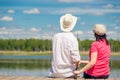 Family couple with a fishing rod sitting on a wooden pier Royalty Free Stock Photo