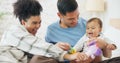 Family, couple and quality time with baby, mom and dad playing with toys for fun, laughing together in home, bedroom or Royalty Free Stock Photo