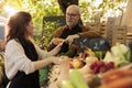 Family couple selling organic farm goods at farmers market Royalty Free Stock Photo