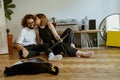 Young couple kissing while sitting on floor and listening music on vinyl player with records at home Royalty Free Stock Photo