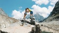 Family couple of tourists in the mountain trek climb to the top of the stone and raise their hands up, kiss and enjoy Royalty Free Stock Photo