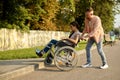 Family couple with wheelchair overcomes the curb