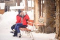 family couple in a winter clothes sitting on a wooden bench Royalty Free Stock Photo