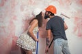 Family couple working and repair. Builder man kiss girl in helmet with tool. Building and construction. Man and woman in Royalty Free Stock Photo