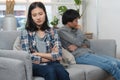 Family crisis. Asian wife crying on the sofa after husband cheating on her