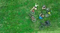 Family cycling on bikes outdoors aerial view from above, active parents with child have fun and relax on grass, family sport